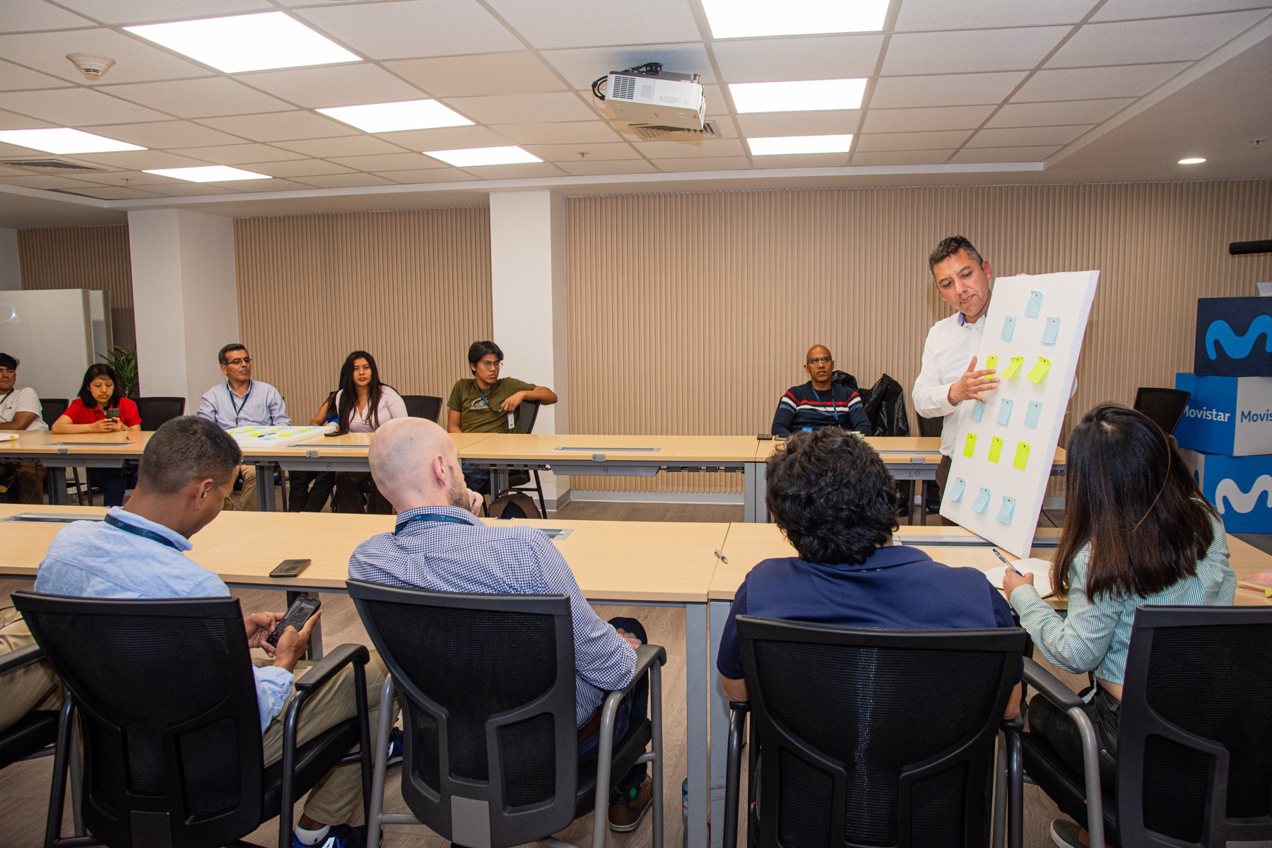 Roberto Aguirre mostrando un tablero de notas adhesivas durante un taller